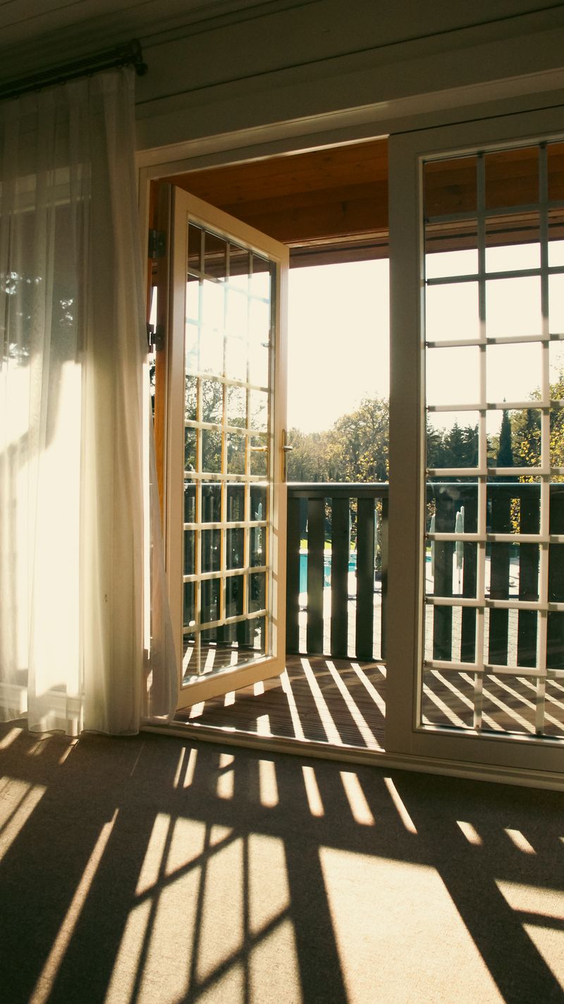 French doors with full glass panels opening to a balcony