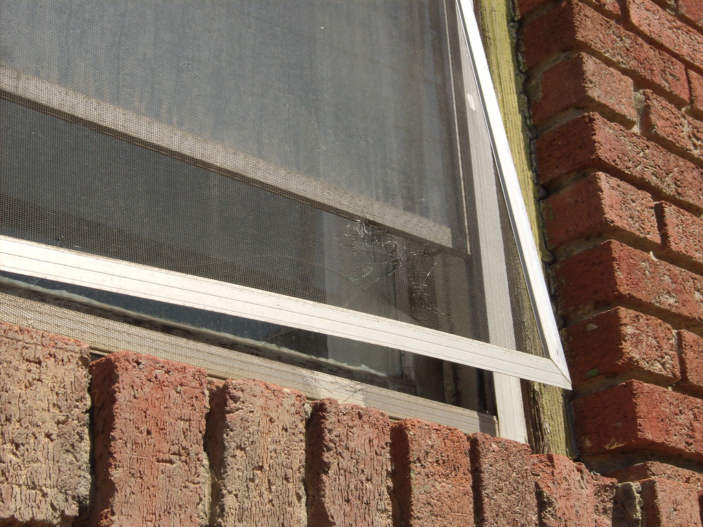 Torn and damaged window screen mesh